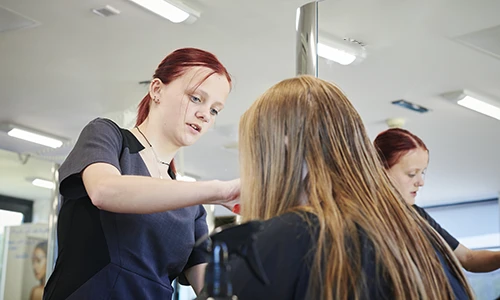 Hairdressing student cutting hair