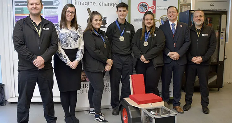 Students and staff in front of engineering project