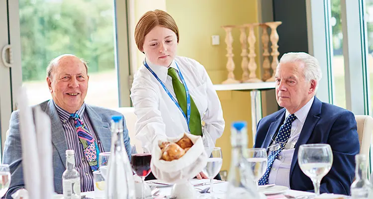 Student serving customers in college restaurant 