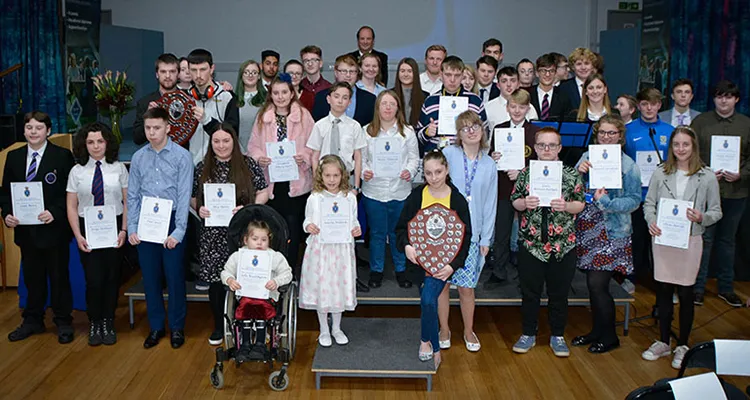 Young people of all ages in group holding certificates