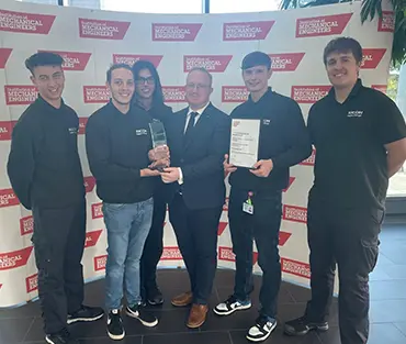 Group of apprentices students receiving trophy from employer