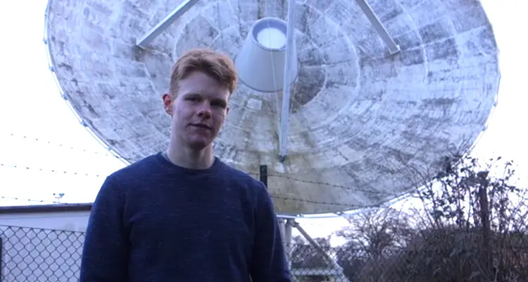 Student standing in front of satellite