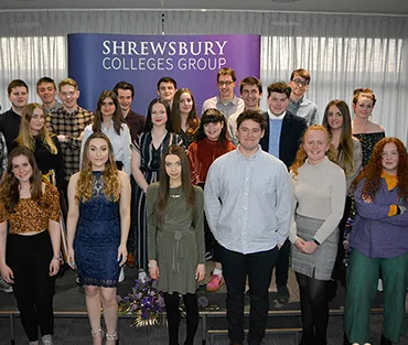 Large group of smartly dressed students standing in front of banner