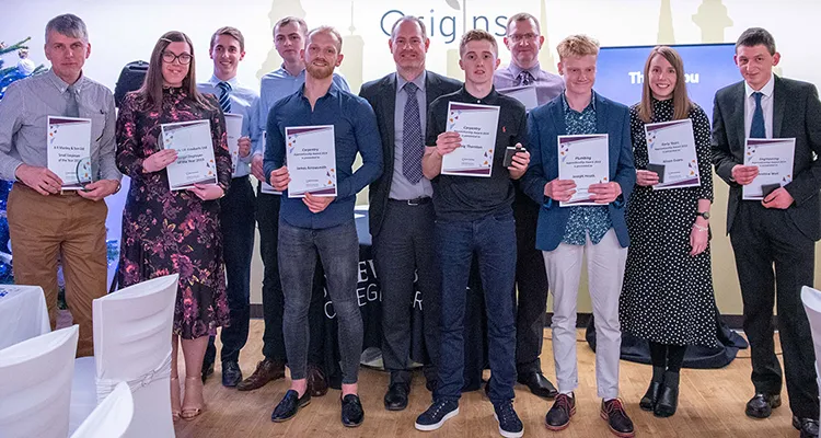 Large group of apprentices holding certificates either side of the College's Head of Apprenticeships