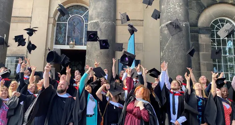 Graduation students throwing their cap outside St Chads