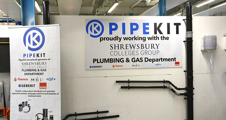 Sign and banner showing PipeKit and SCG logo