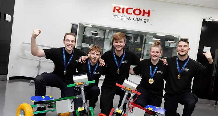 Small group of students smiling in front of made bikes