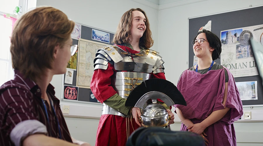 A student dressed in Roman armour and one with civilian clothes