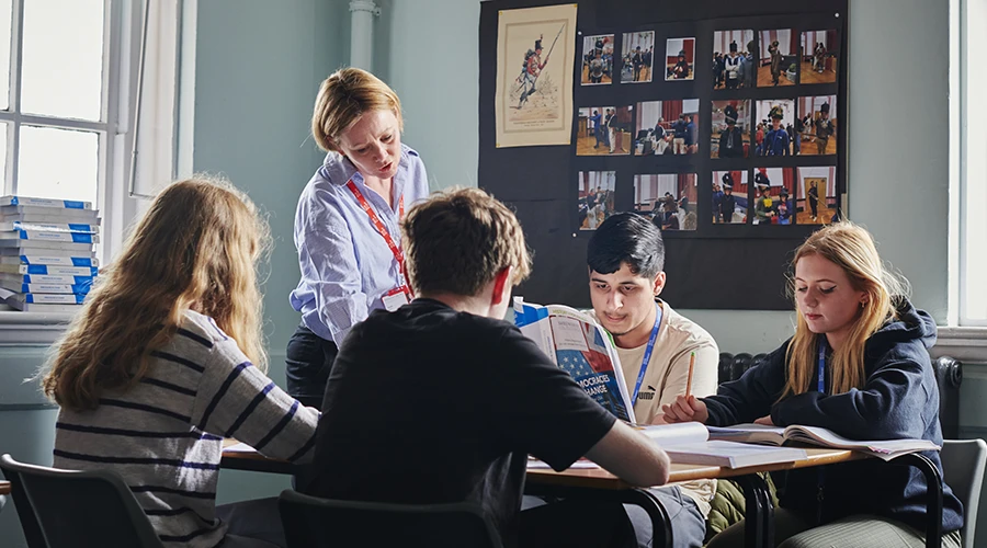 Students with teacher reading books and writing