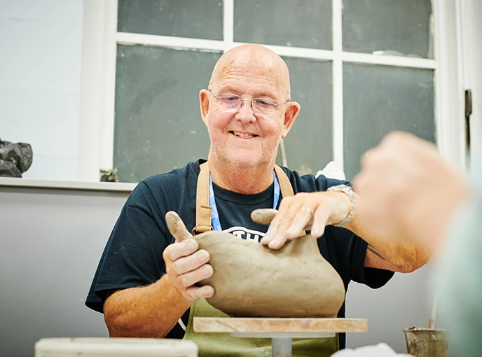 Man making sculpture out of clay