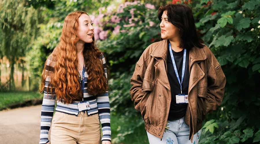 two students walking through garden