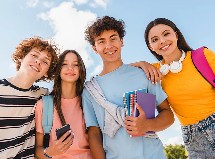 four young students and bright sky